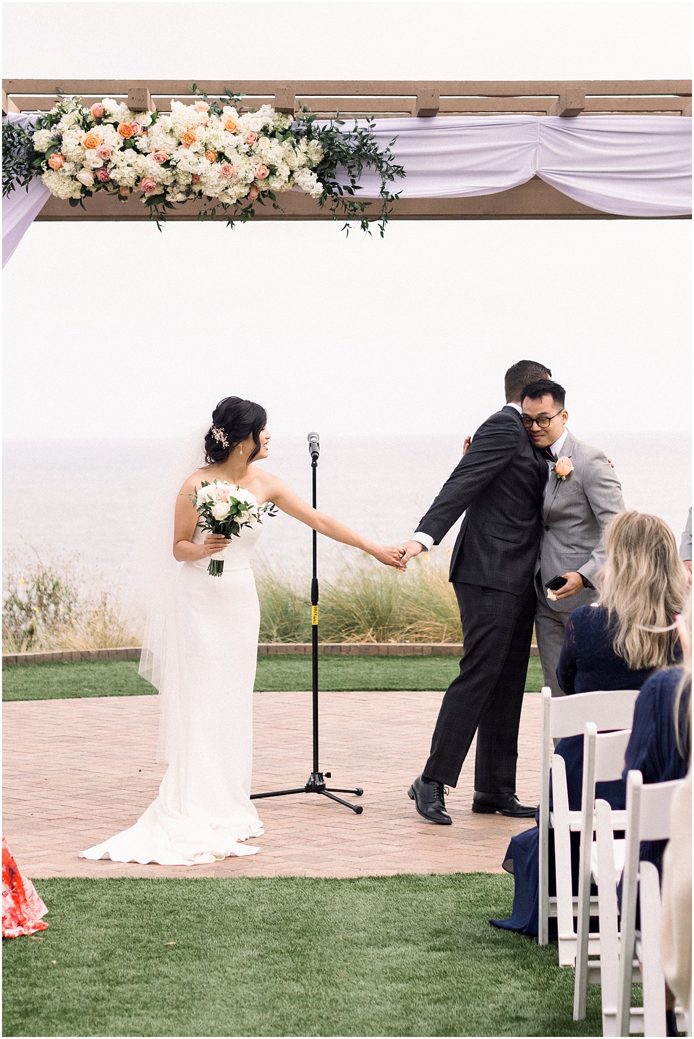 Groom hugging brother during ceremony at Terranea Resort.