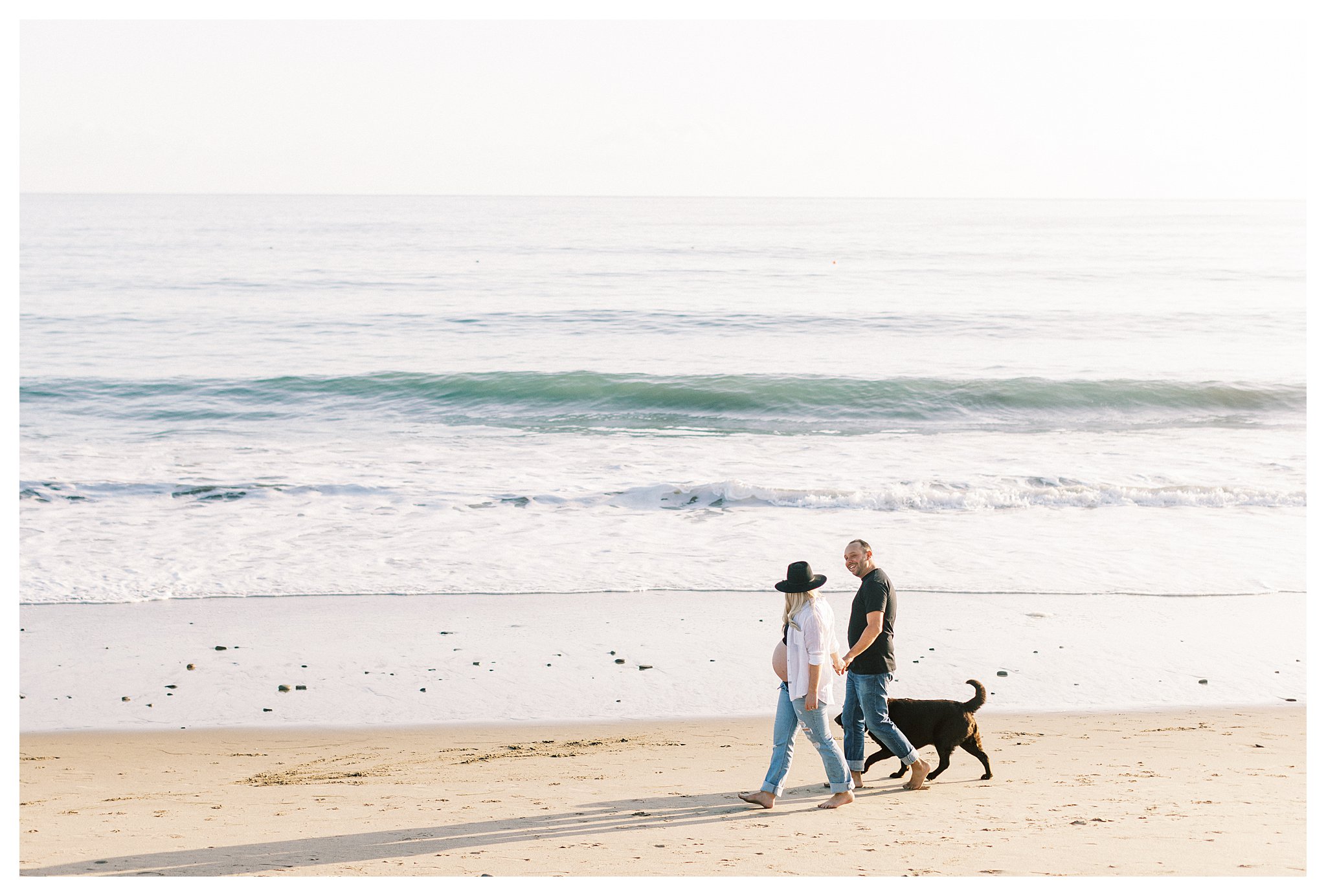 A couple walking with their dog during their photo session in Malibu, Ca.
