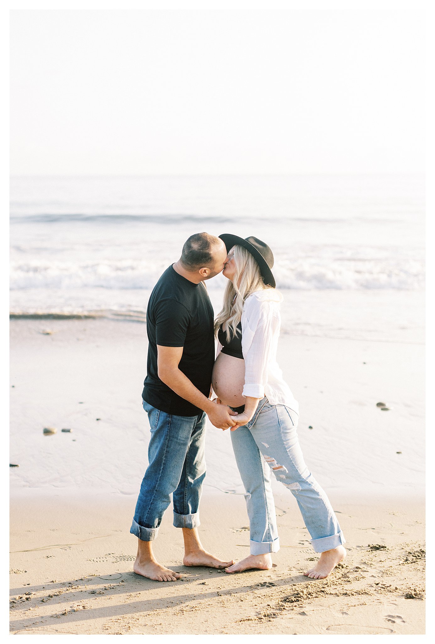 A couple kissing on the beach during maternity photo session in Malibu, Ca.