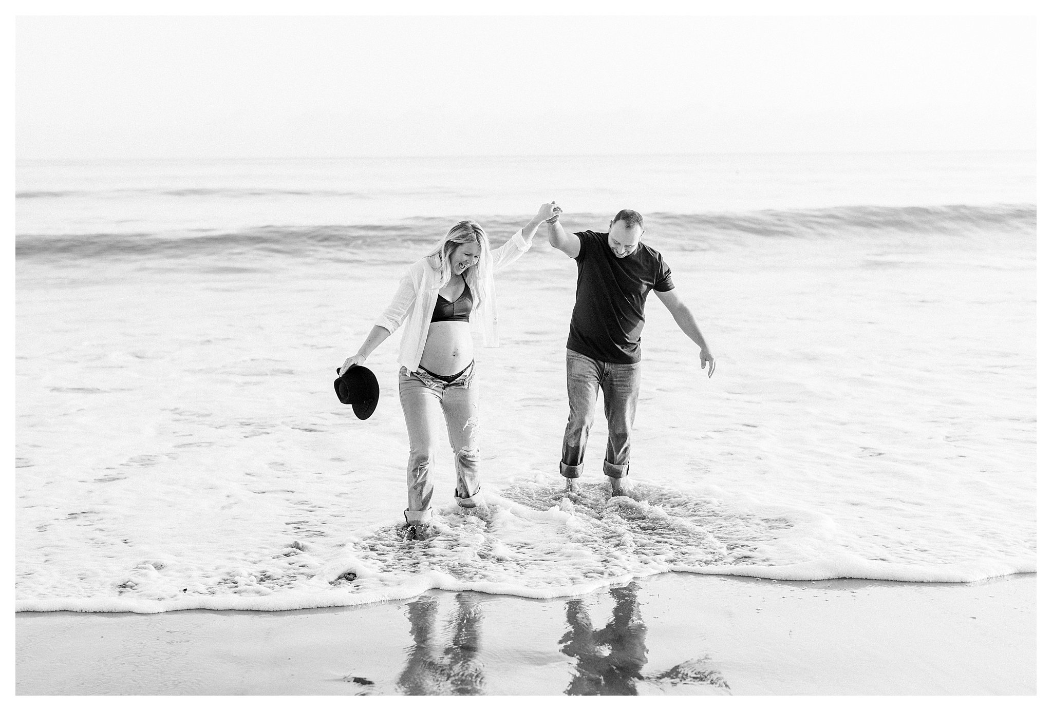 A pregnant couple having fun in the water during their maternity session in Malibu, Ca. 