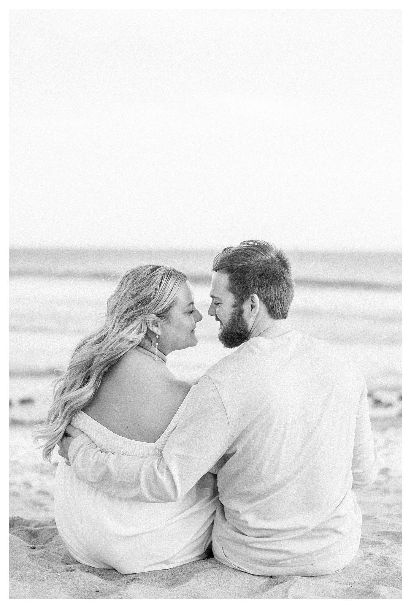 A couple snuggling on the beach at Leo Carrillo.  