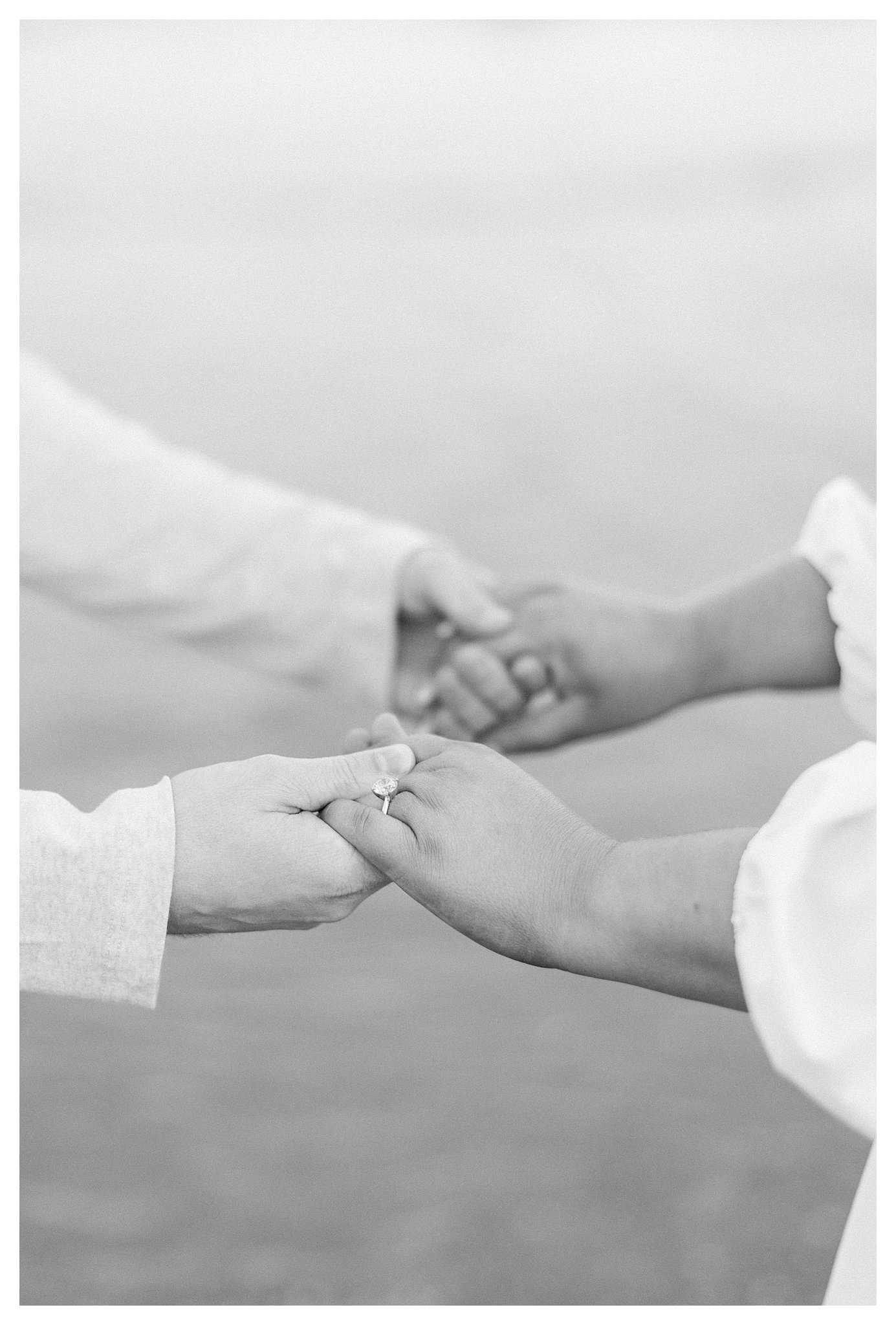 A romantic, hand-in-hand moment featuring her diamond ring during their engagement session.   