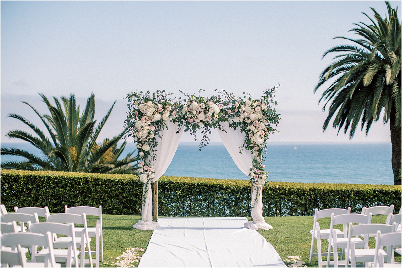 Wedding arch adorned with flowers at Bel Air Bay Club wedding.  