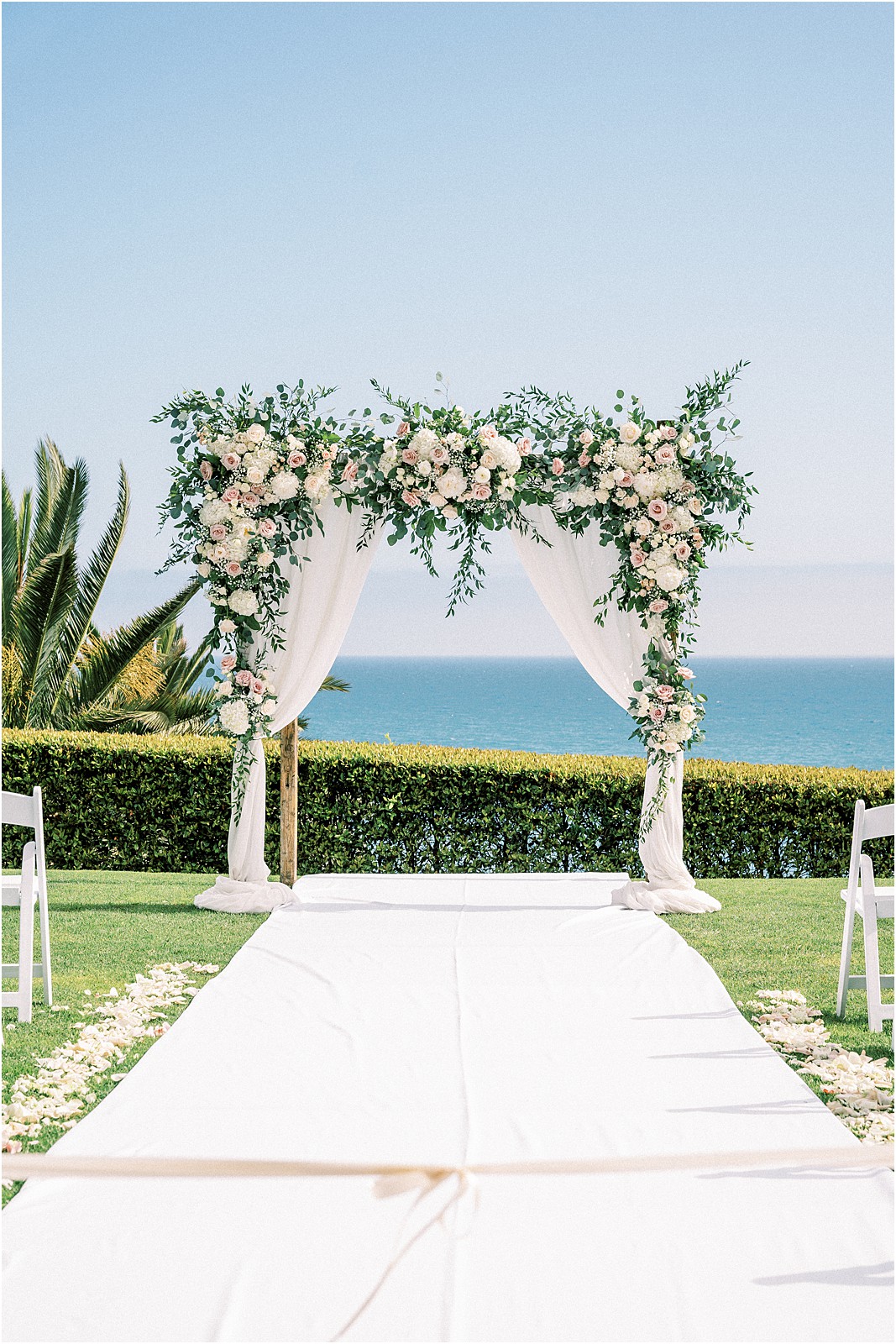 The ceremony arch adorned with flowers at Bel Air Bay Club in Pacific Palisades.