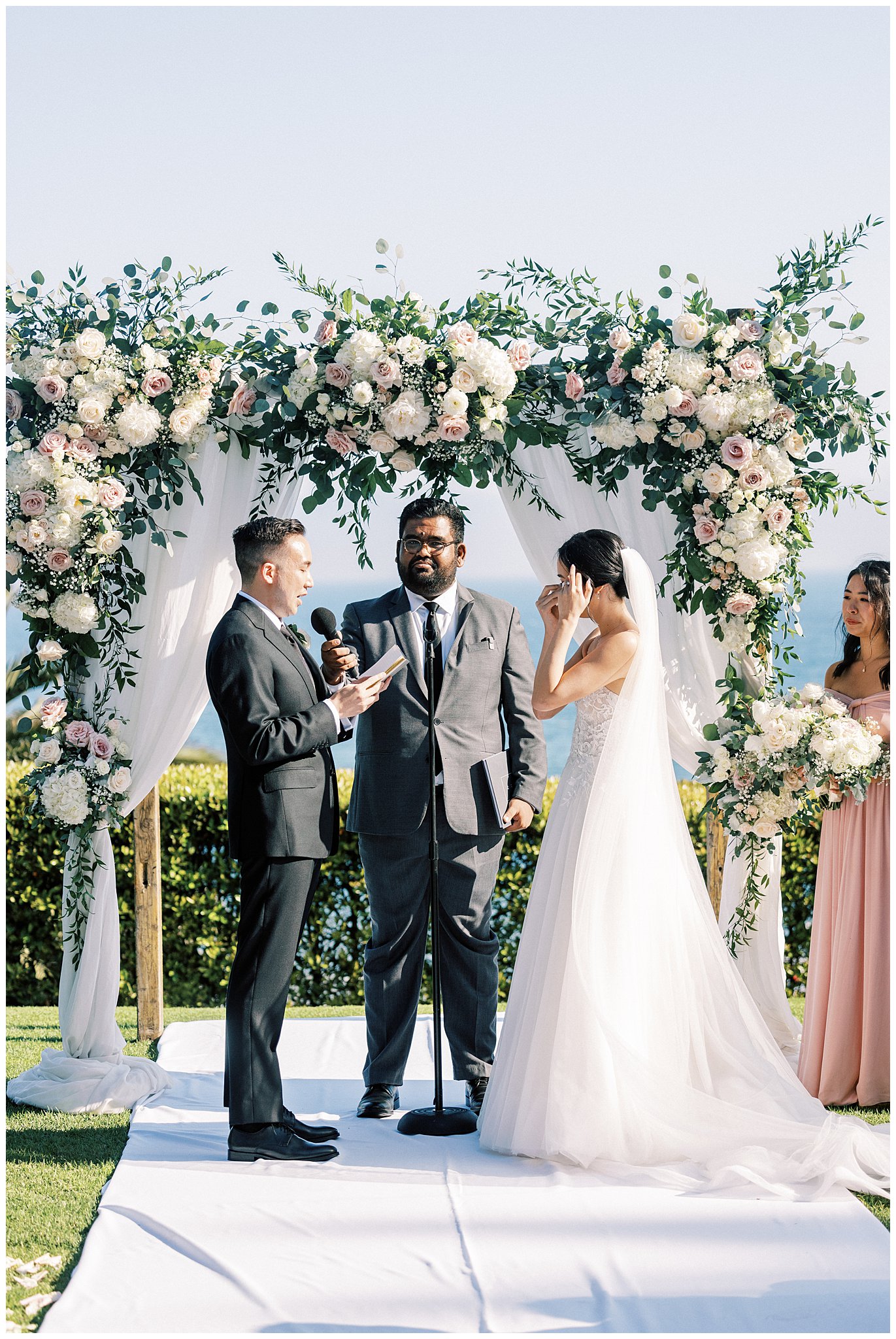 The bride wiping tears during the grooms vows at Bel Air Bay Club.  