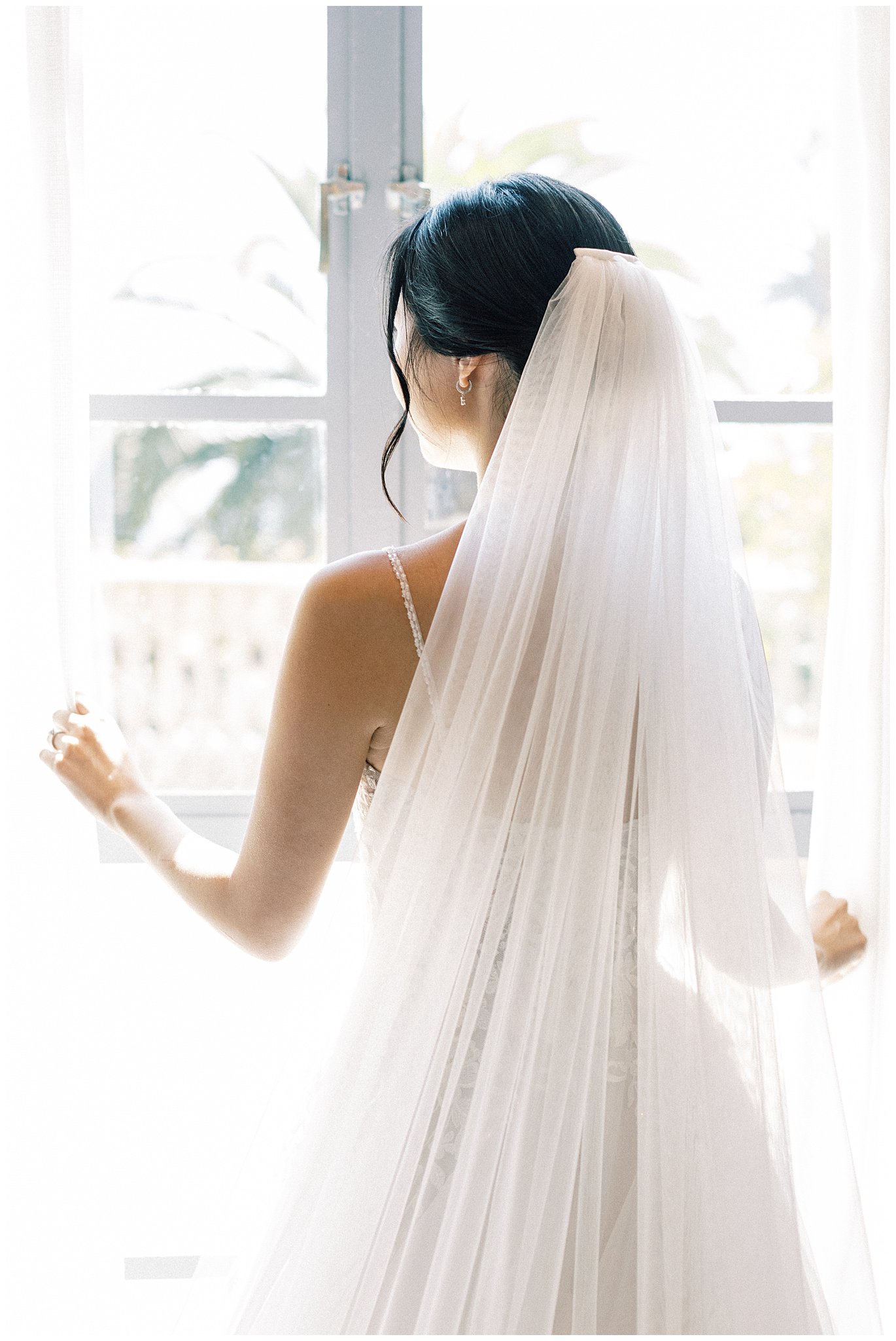 The bride looking out the window at Bel Air Bay Club.  