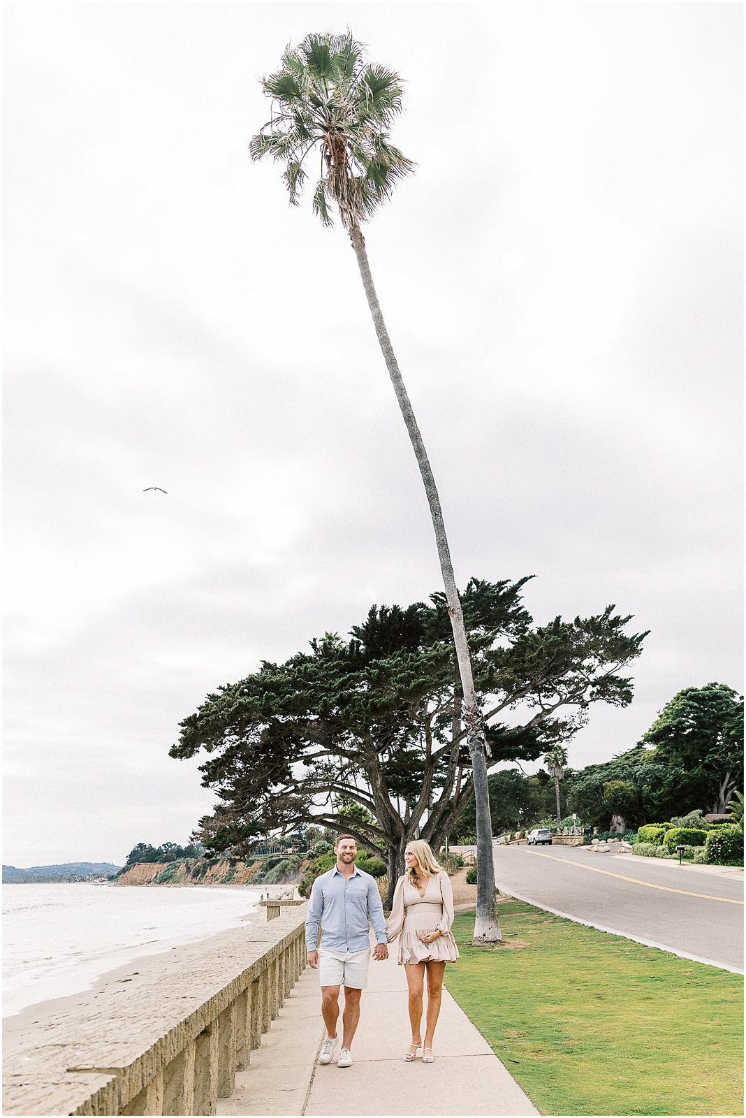 An expecting couple walking hand in hand in Montecito, Ca.