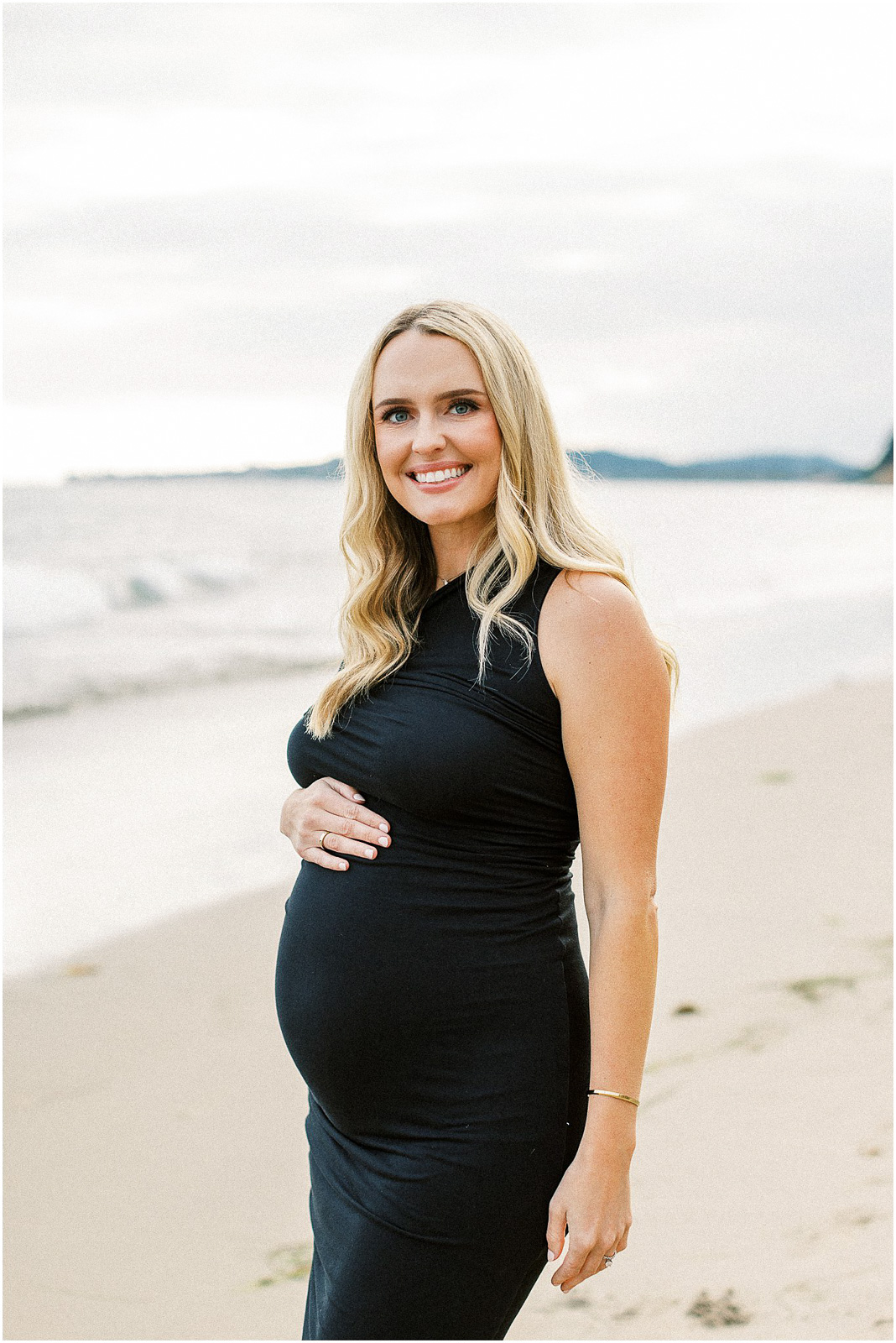 A pregnant mom standing on the beach in Montecito, Ca.