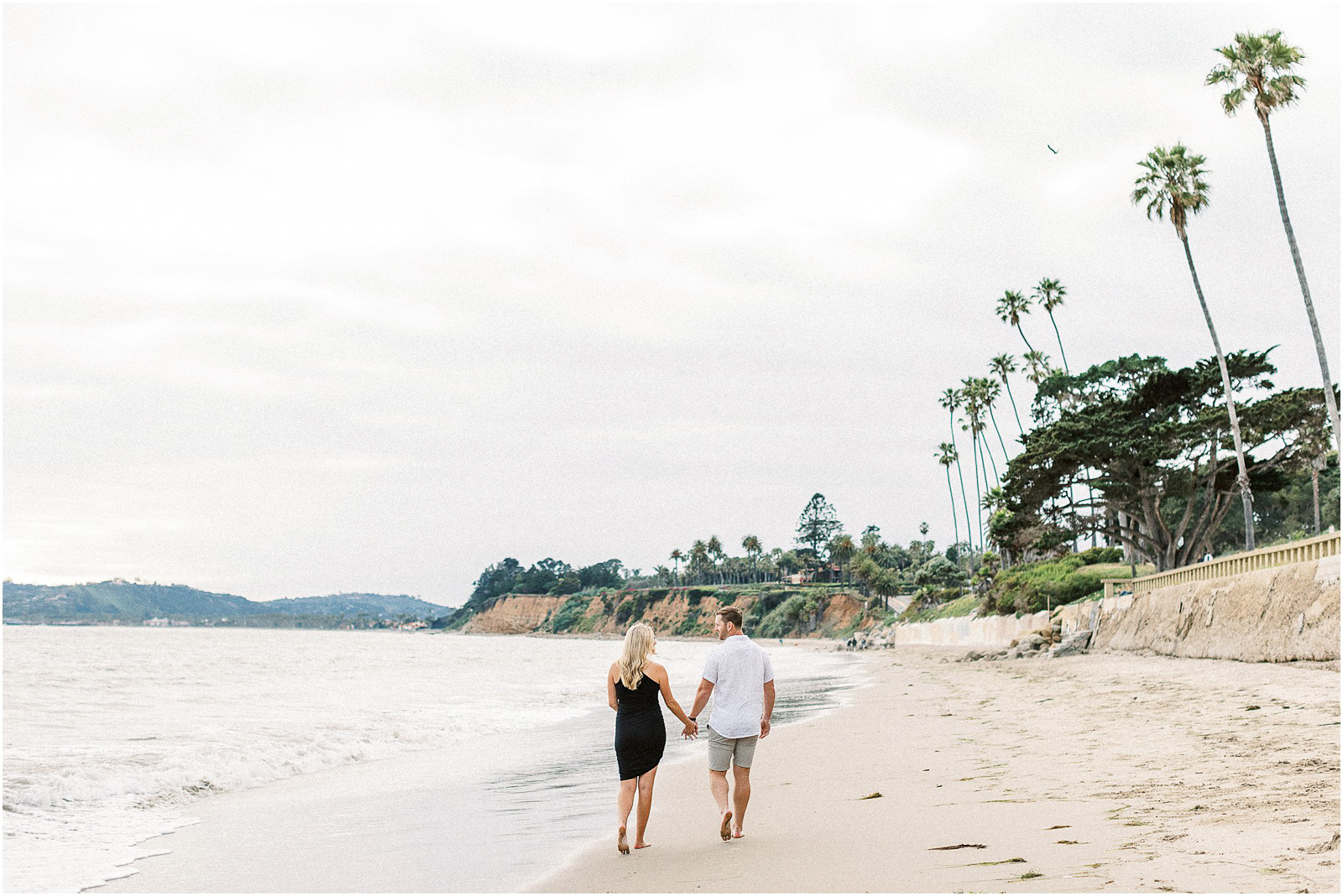 Husband and wife walking down the beach in Montecito, Ca.
