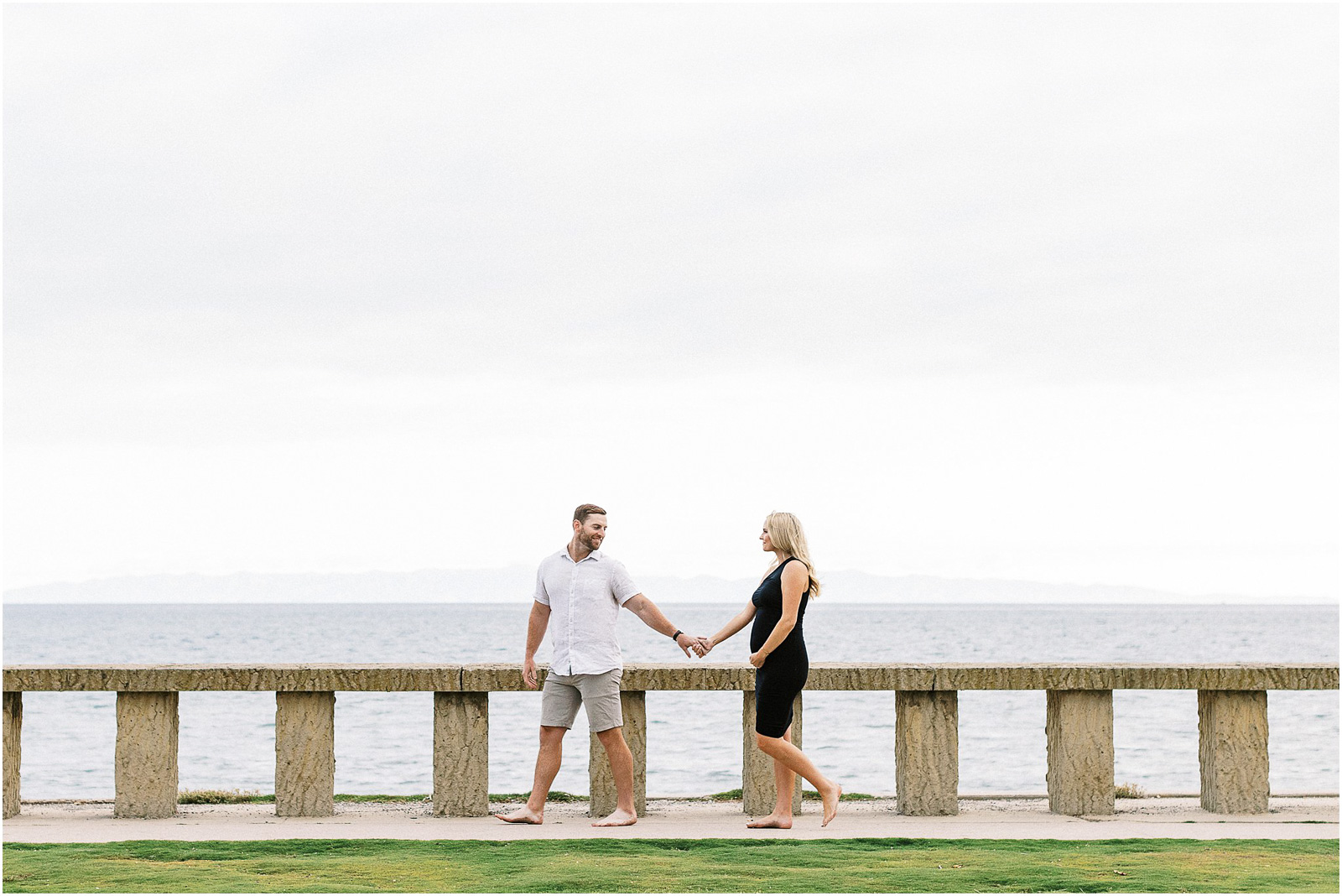 Husband leading his pregnant wife along the beach in Montecito, Ca.