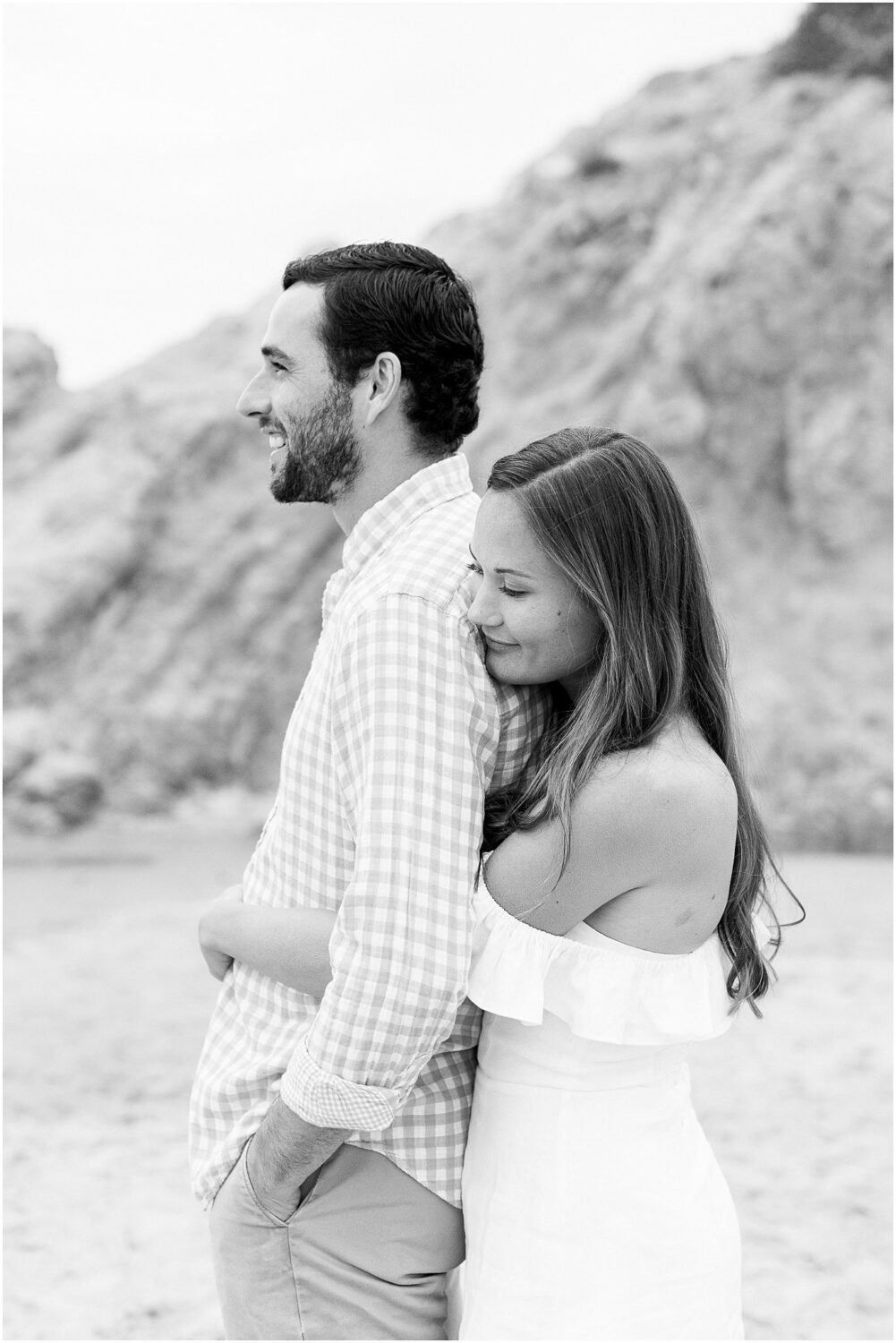 A woman hugging her fiance from behind in Malibu, Ca.