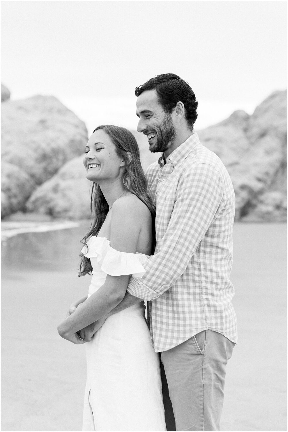 A couple laughing on the beach in Malibu.  