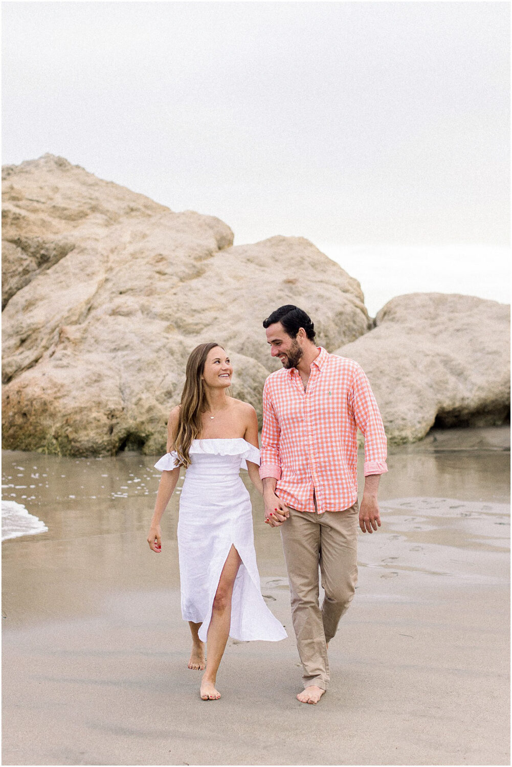 A newly engaged couple walking along the beach at Leo Carrillo in Malibu, Ca.