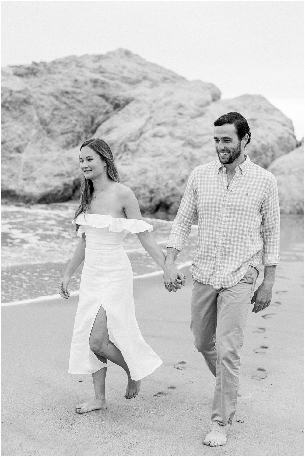 A couple walking hand in hand along the Leo Carrillo beach in Malibu, Ca.