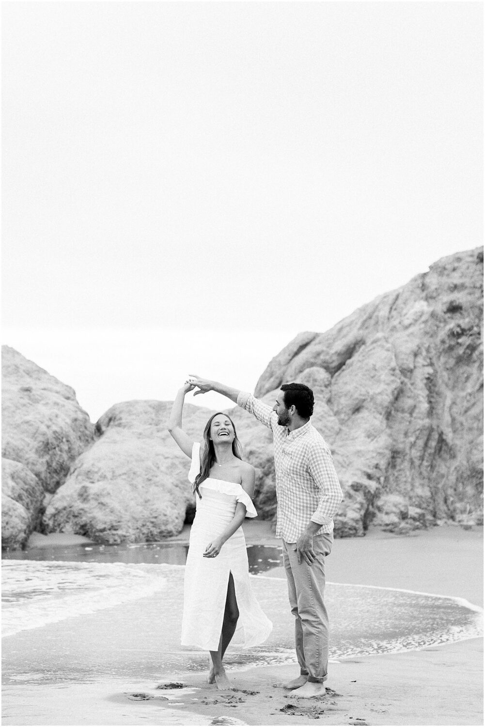 An engaged couple dancing on the sand in Malibu, Ca.