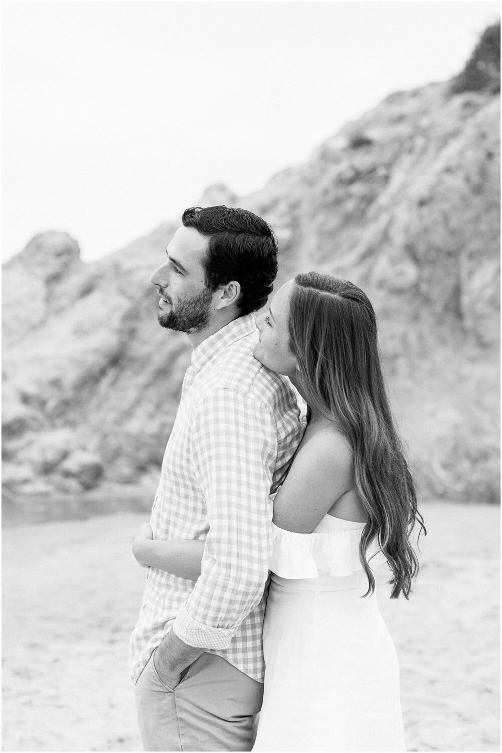 A couple embracing on Leo Carrillo Beach in Malibu, Ca.