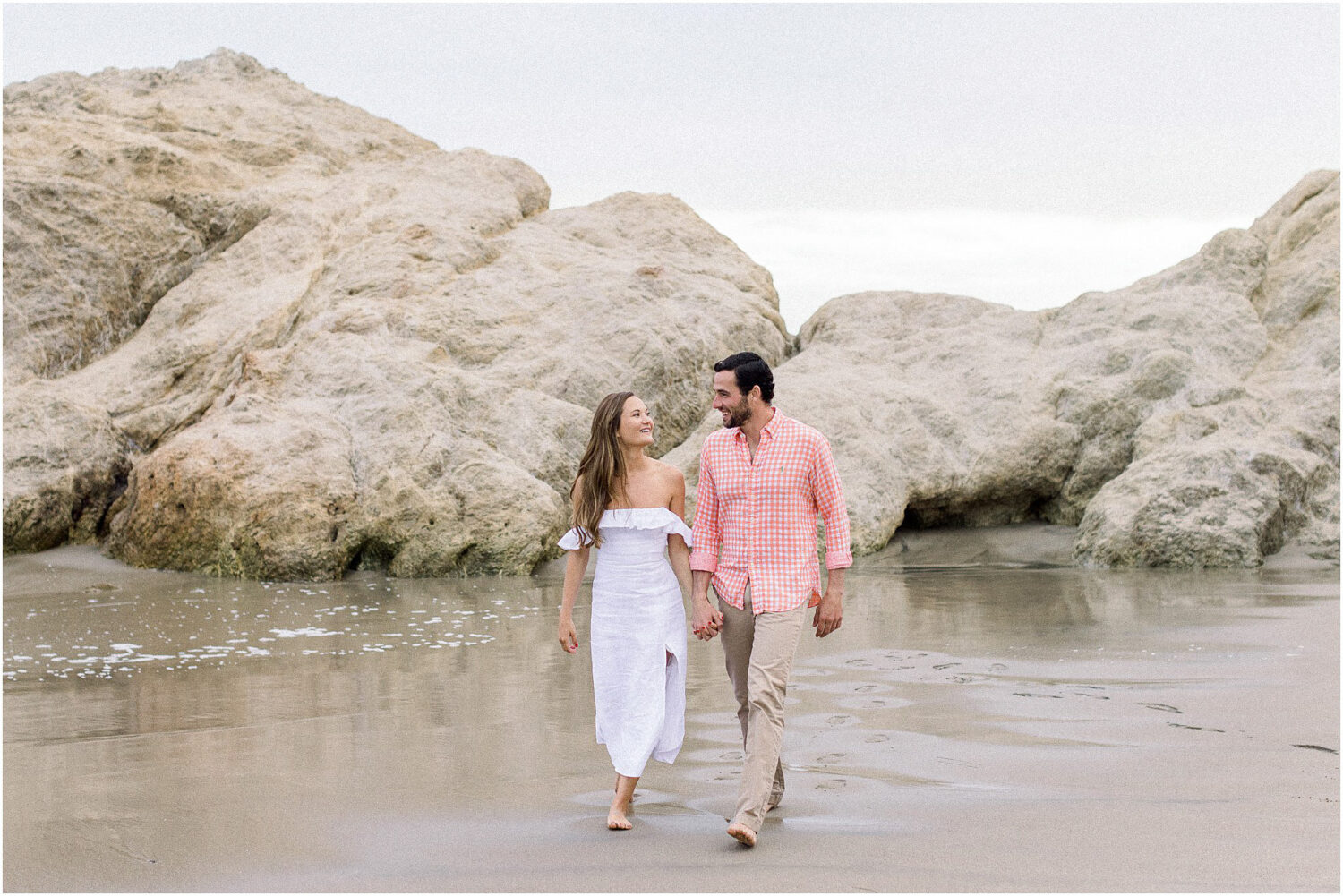 A couple walking on the sand at Leo Carrillo Beach in Malibu, Ca.