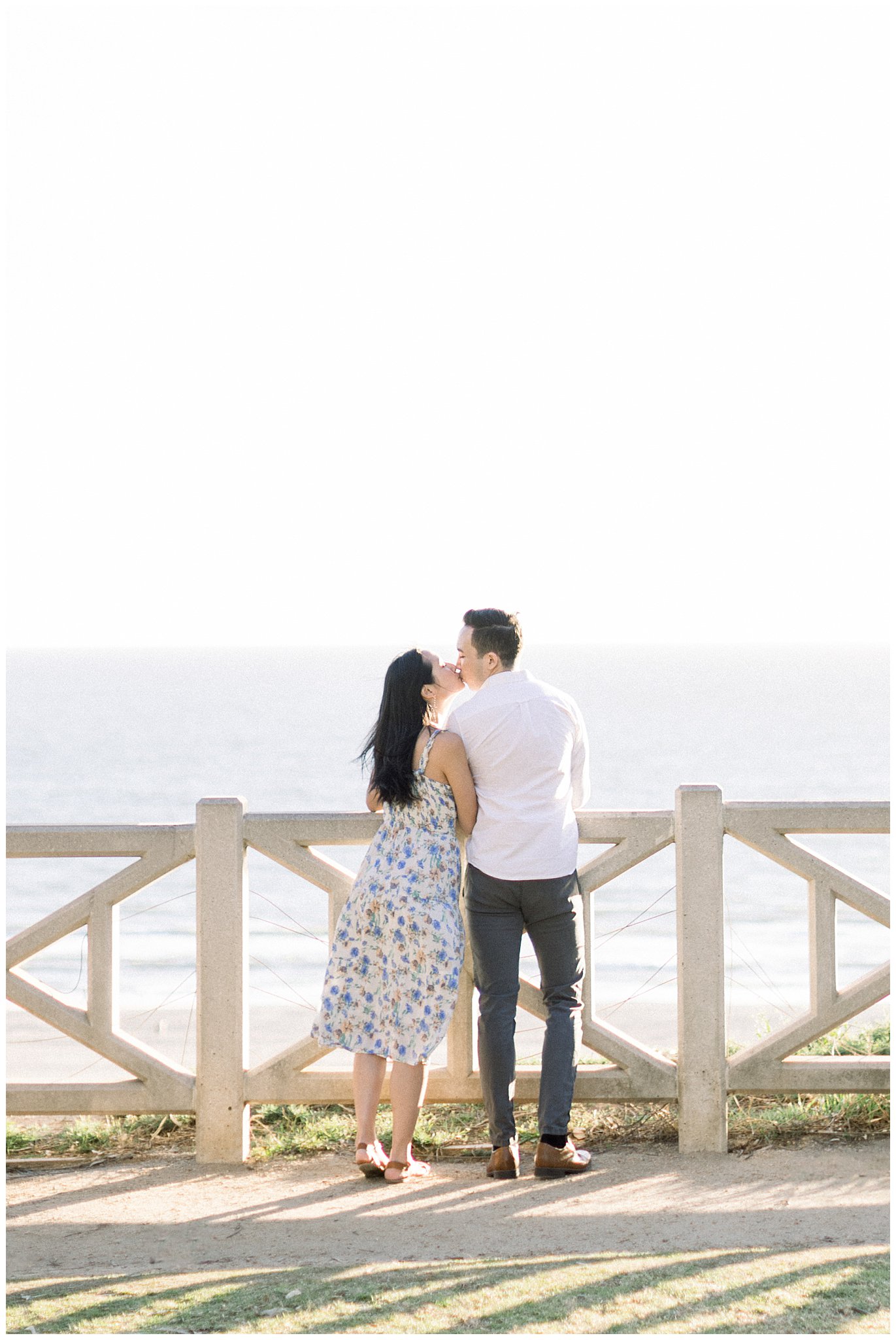 A couple kissing with an ocean view from Palisades Park.  