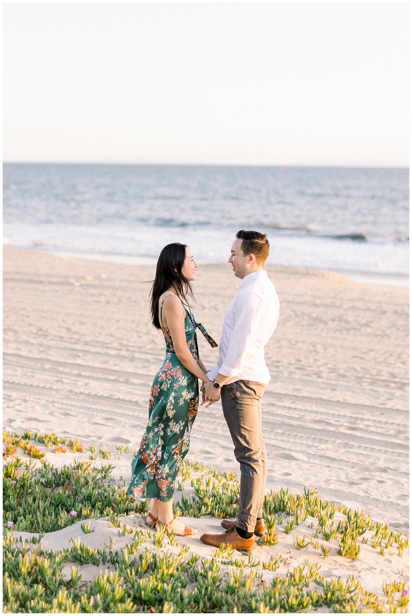 A couple smiling at each other during a photo session at the beach in Pacific Palisades. 