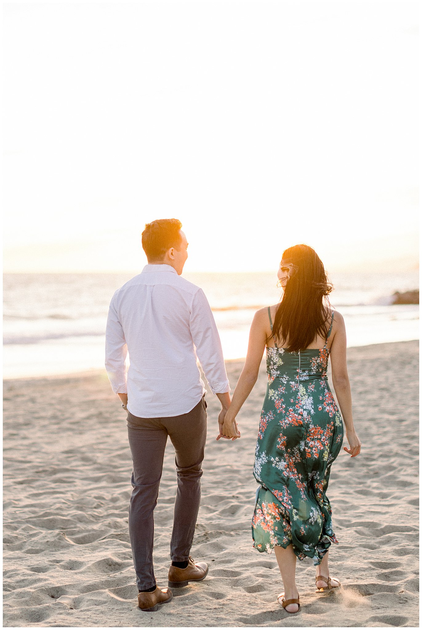 A couple standing together with the ocean breeze blowing at Will Rogers Beach.