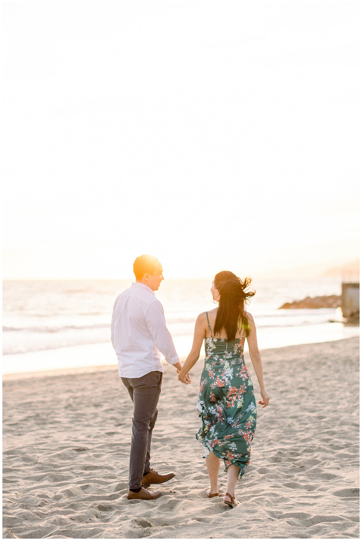 A couples hair blowing in the wind during an engagement session at Will Rogers Beach.