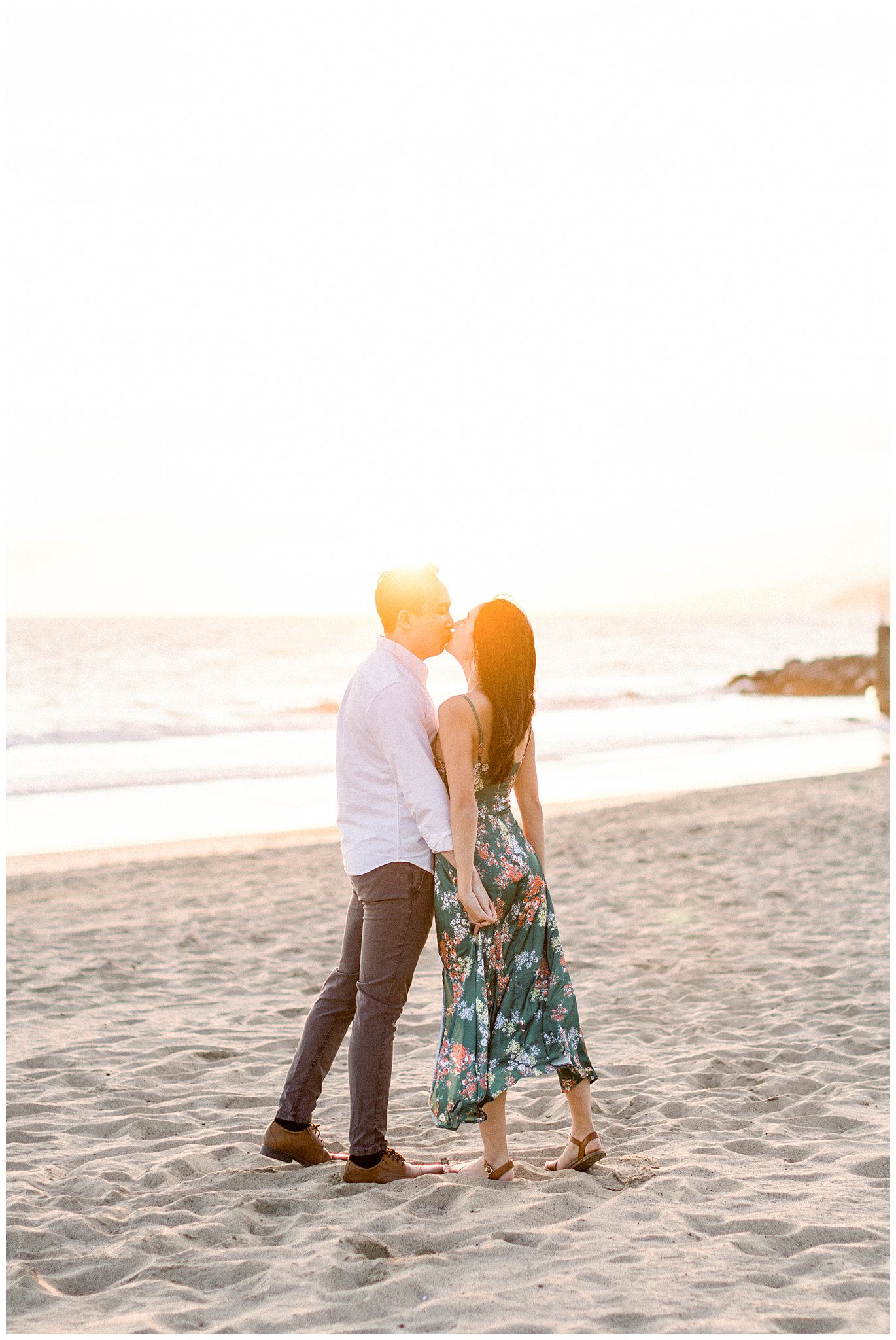 An couple kissing during golden hour at Will Rogers Beach.  