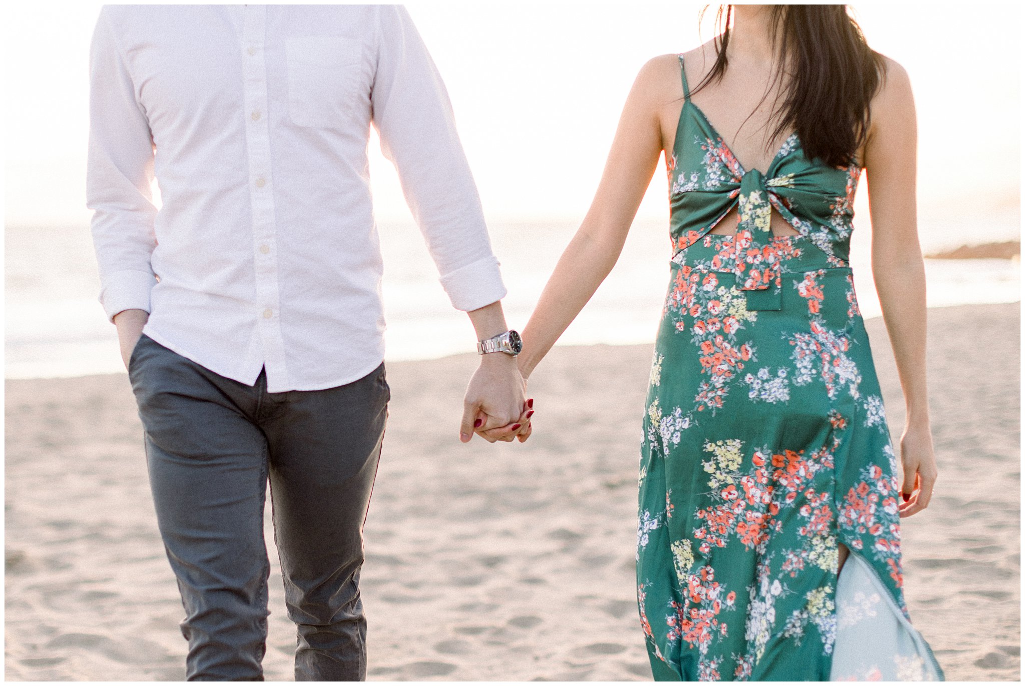 A couple holding hands during an engagement session at Will Rogers Beach.