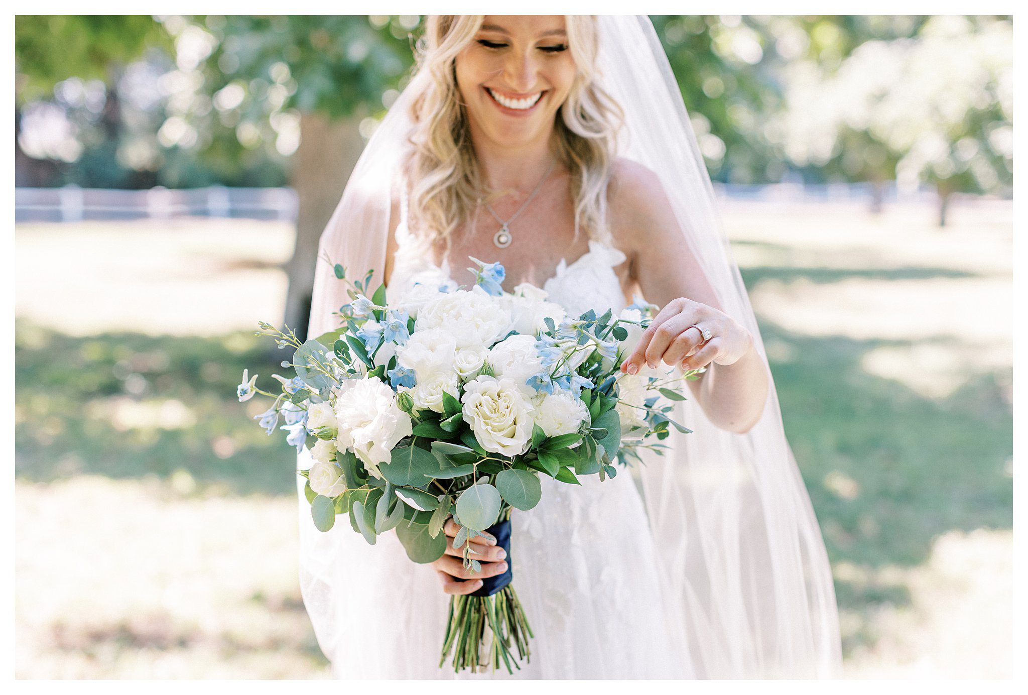 The bride looking at her bouquet at Walnut Grove in Moorpark, Ca.