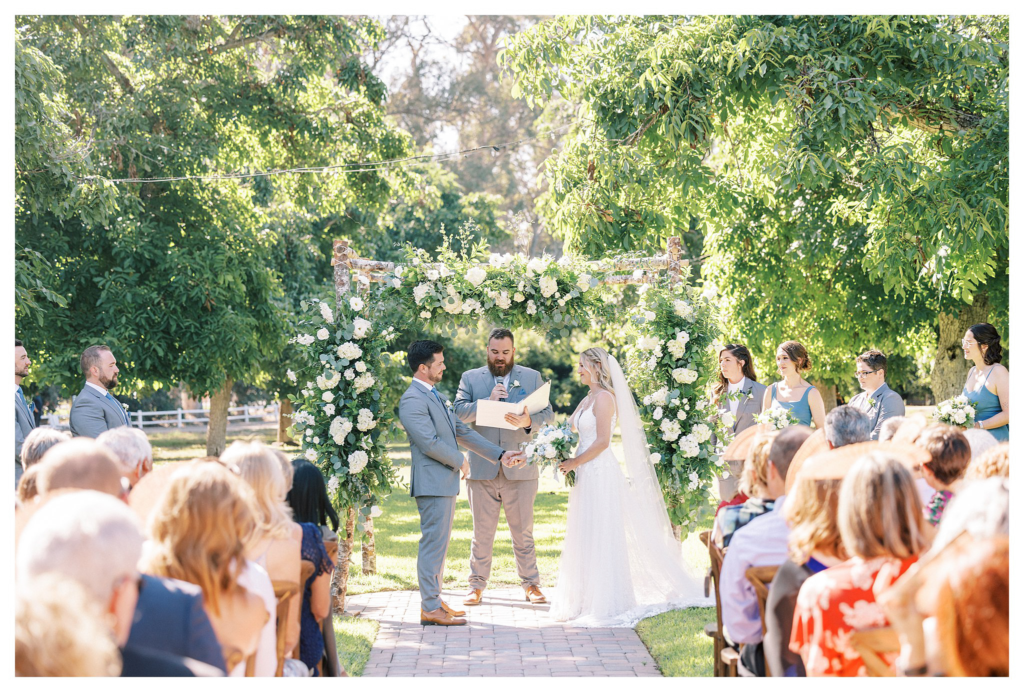 Bride and groom holding hands during the ceremony at Walnut Grove in Moorpark, Ca.