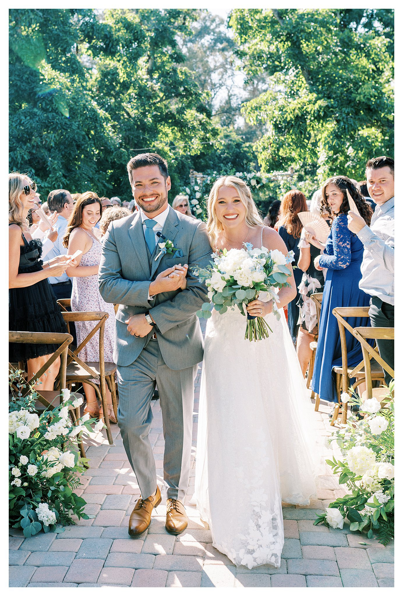 The newlyweds smile as they walk back down the aisle at Walnut Grove in Moorpark, Ca.