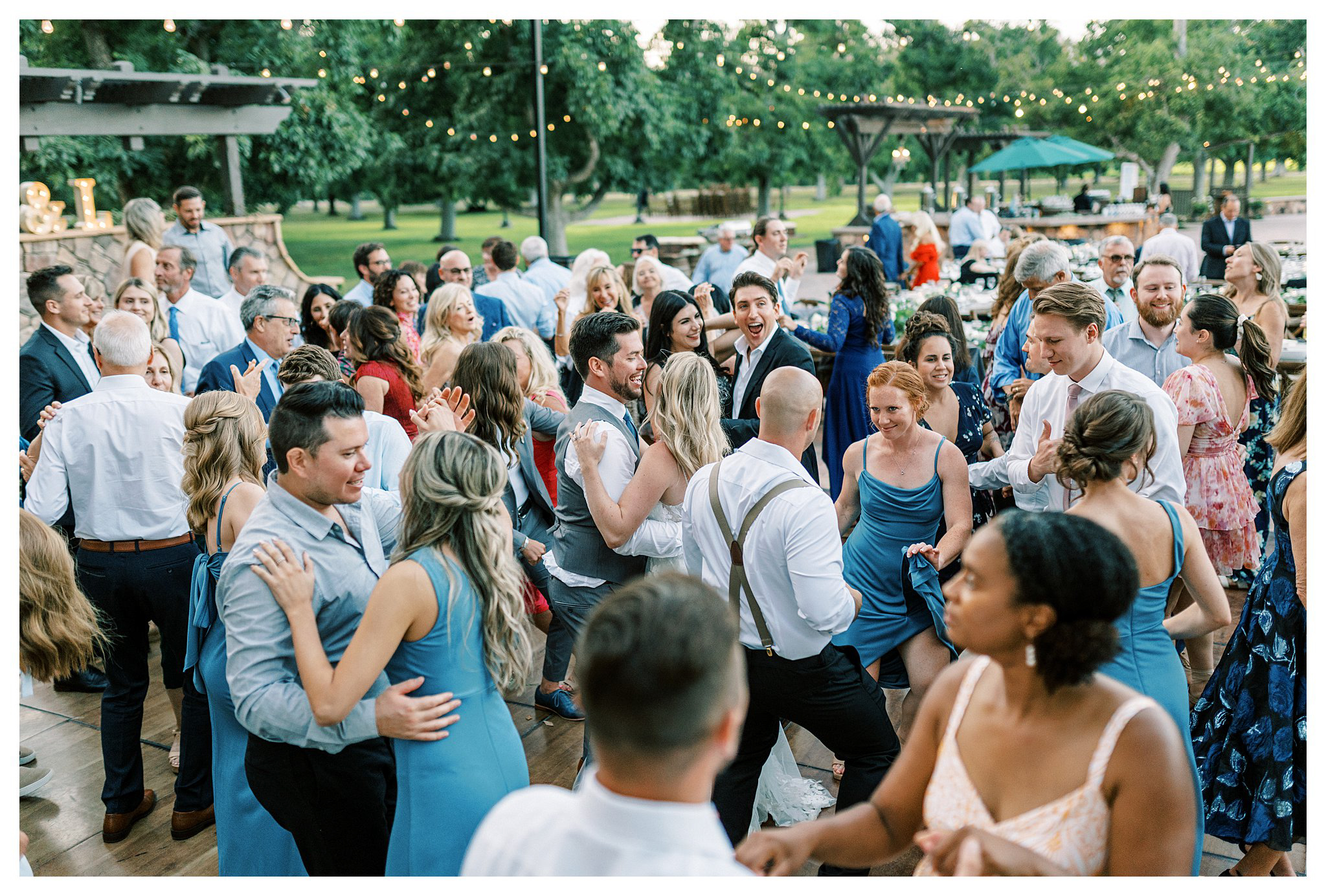 The newlyweds surrounded by family and friends at wedding.  