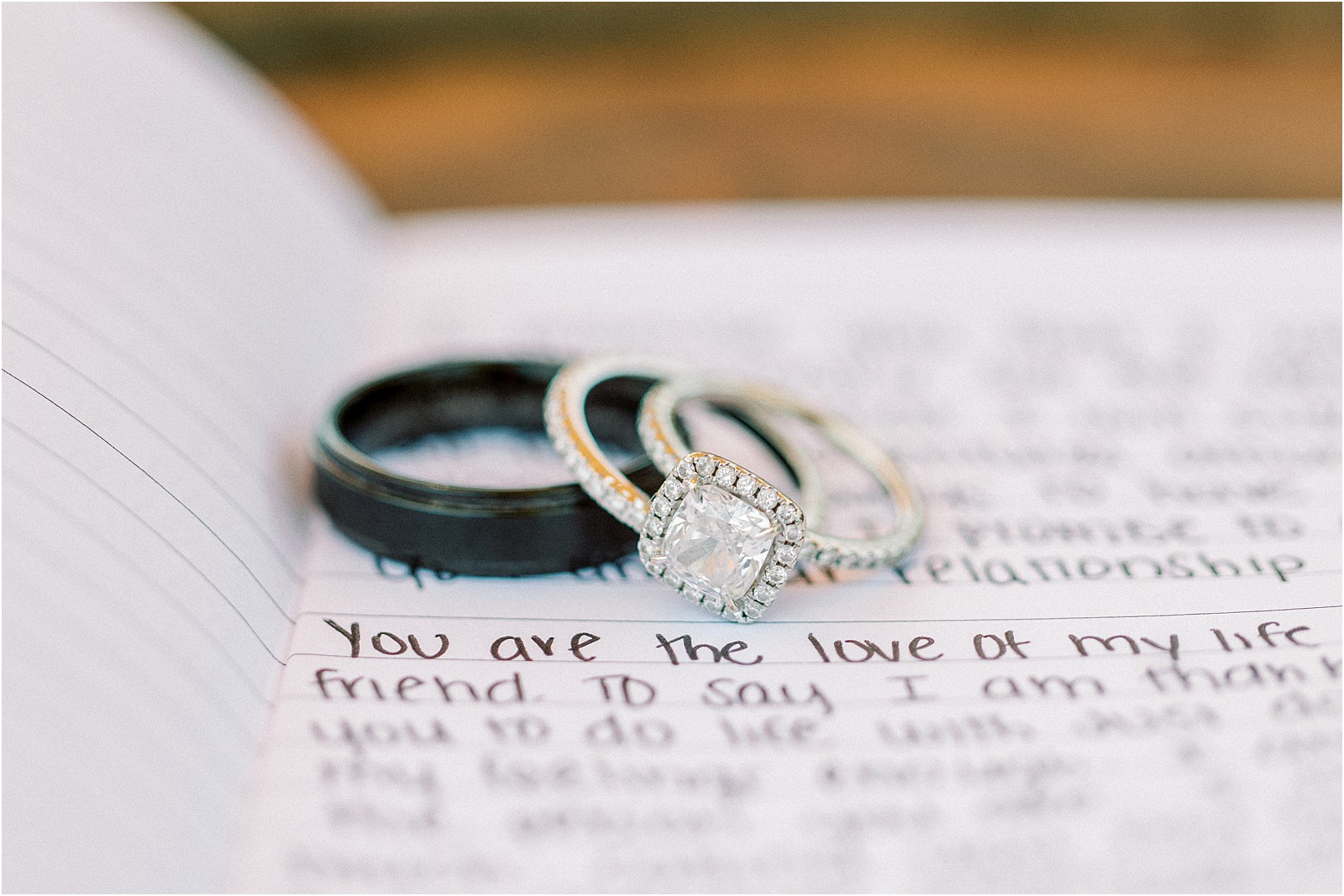 Wedding rings laid out on the handwritten vows.  