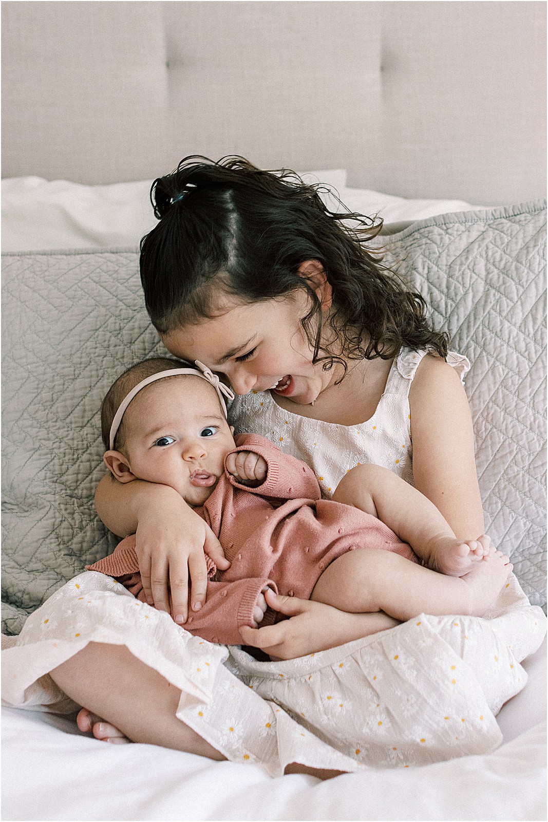 Big sister joyous and snuggling on the newest member of the family.