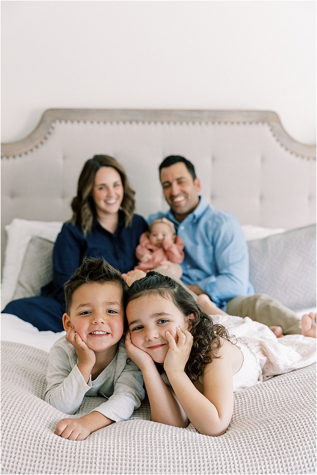 Family of five on the bed cozy during a portrait.