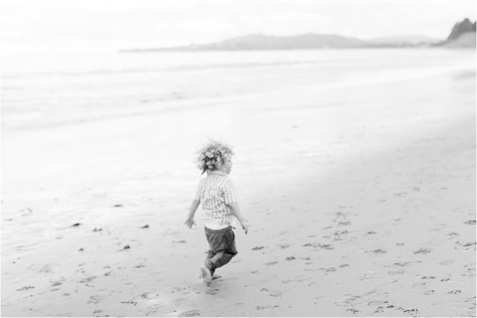 Toddler running around during a foggy beach family session in Santa Barbara