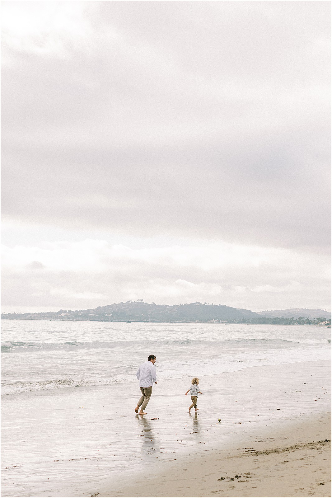 Dad chasing child along the beach in Montecito
