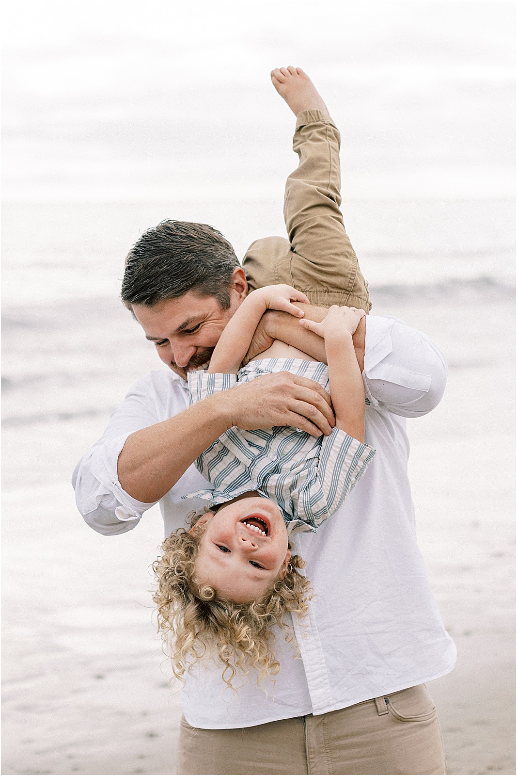 Dad playing with child during an overcast family session in Montecito