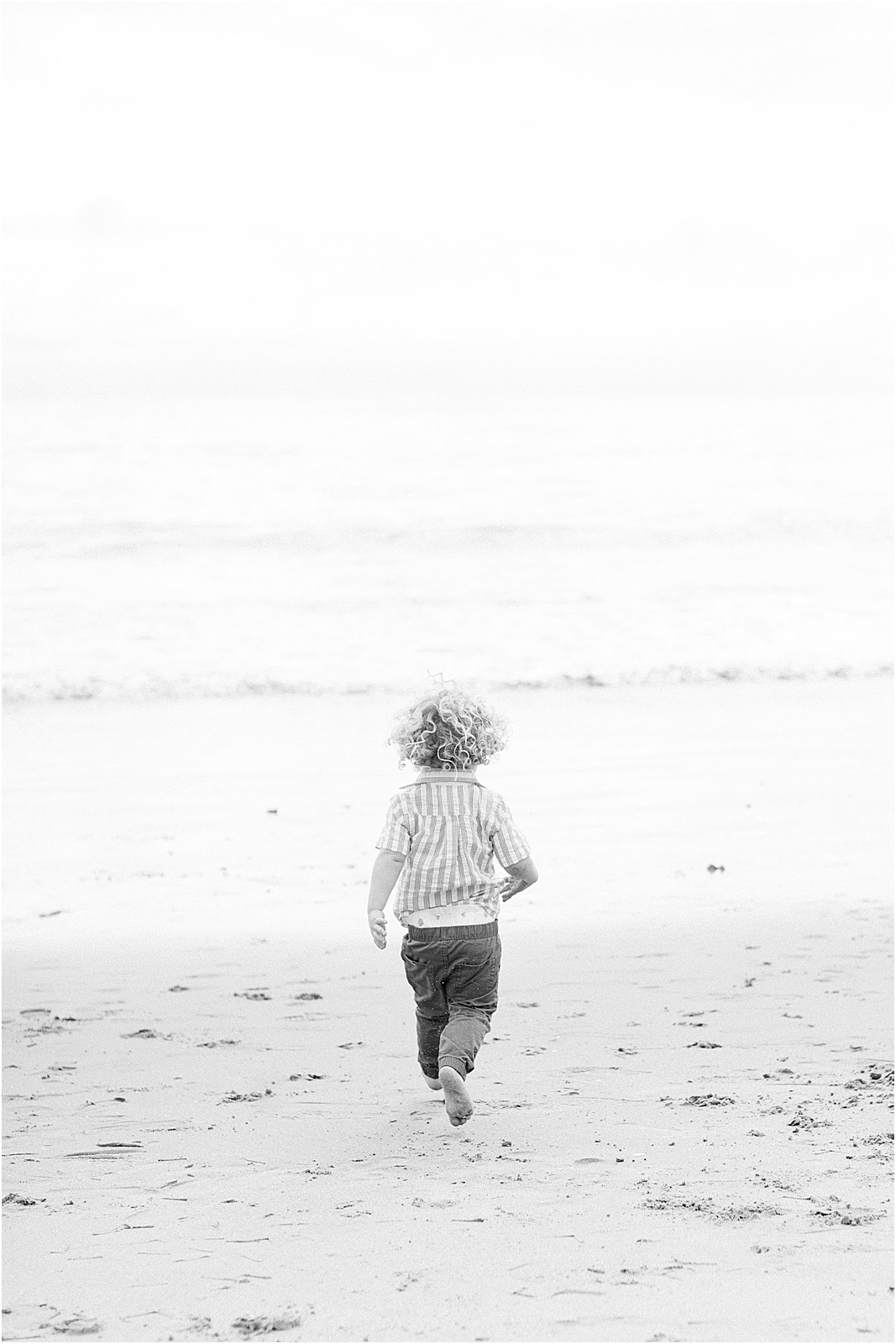 Toddler running around during a foggy beach family session in Montecito