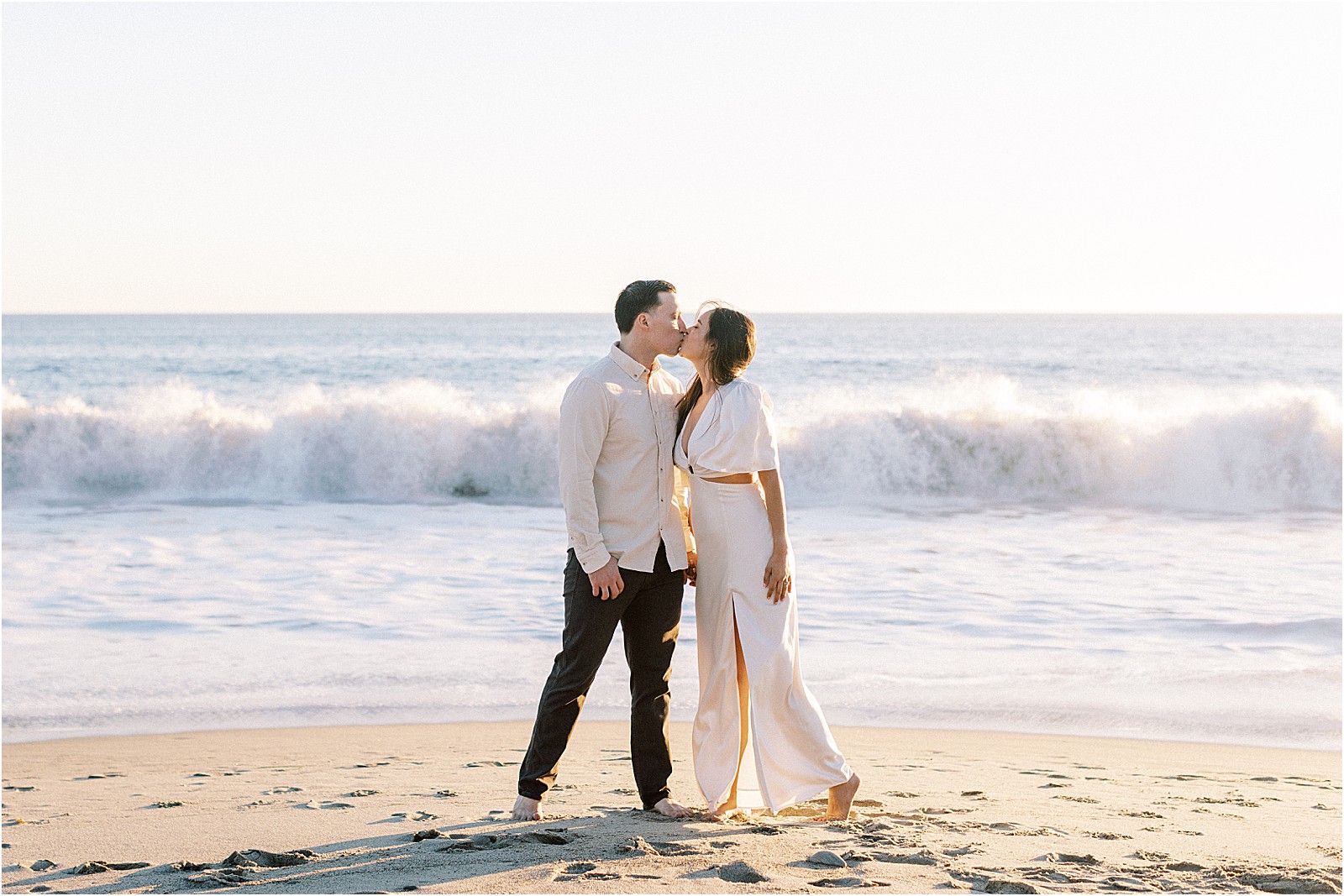 Couple kissing during romantic engagement session in Malibu.