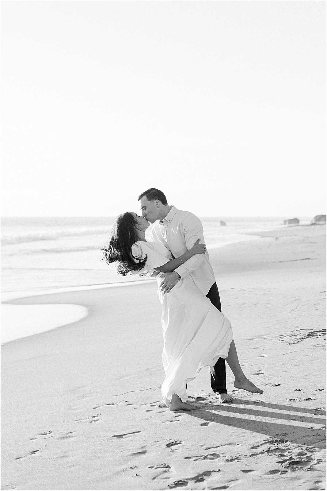 Black and white photo of couple kissing on the beach at Leo Carrillo, Malibu