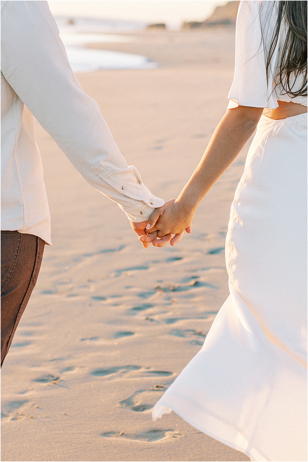 Close-up of couple holding hands at Leo Carrillo Beach