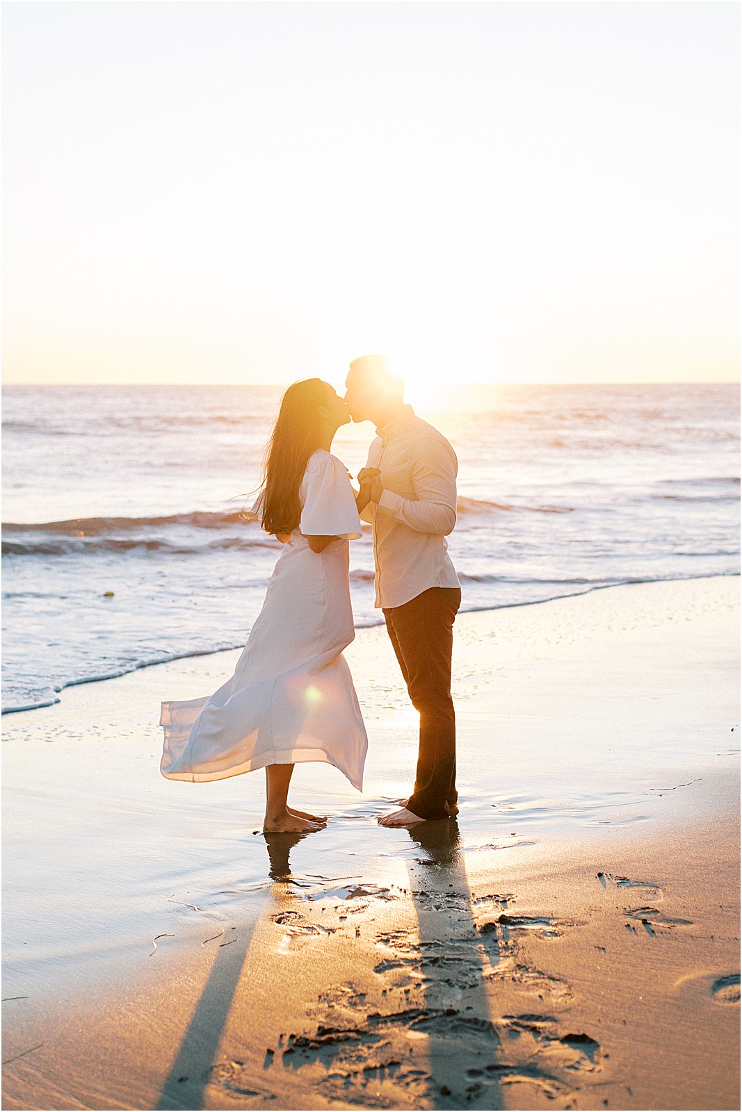 Romantic kiss in the golden light at Leo Carrillo State Beach engagement session.