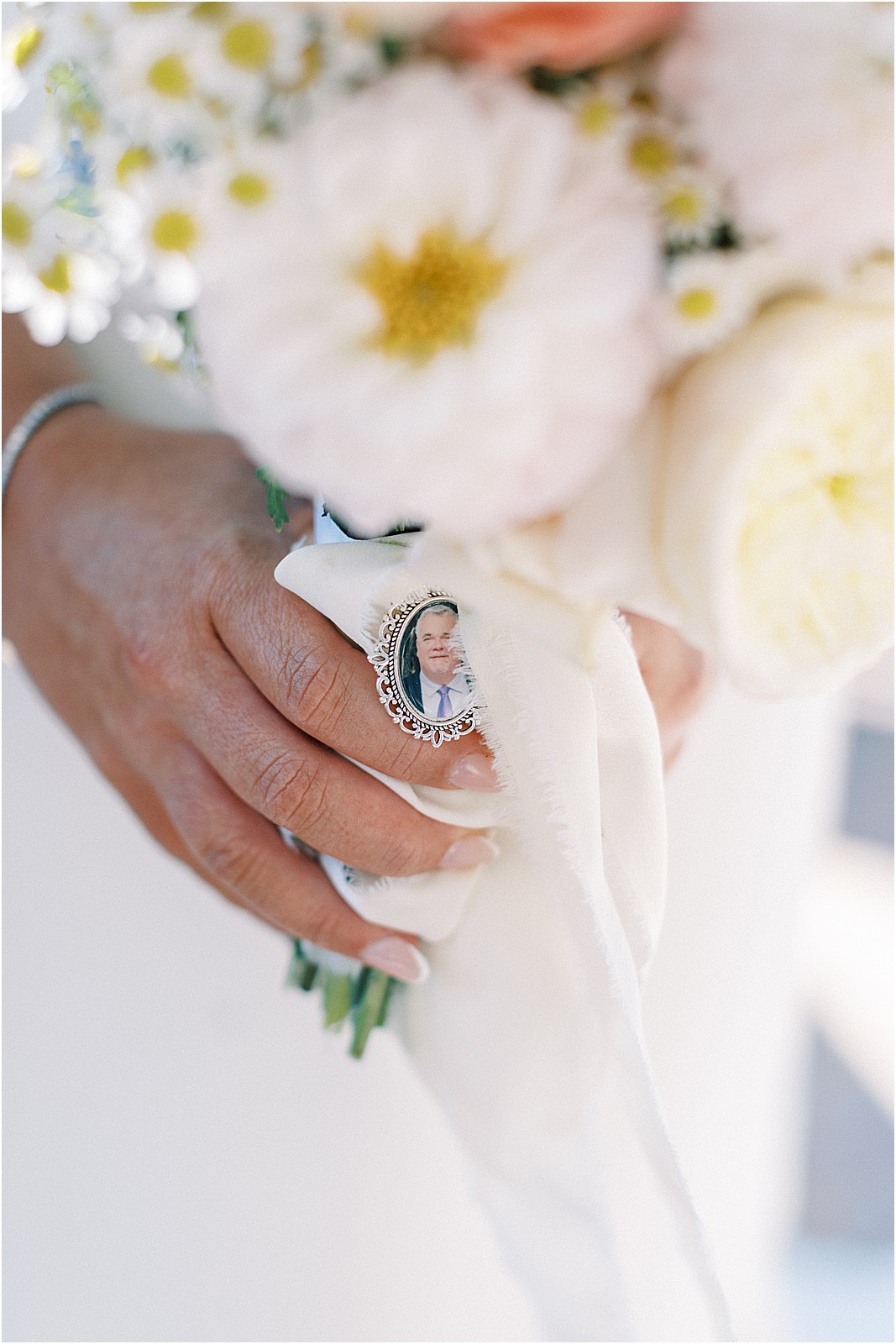 close up of small photo of the father of the bride tied on brides bouquet