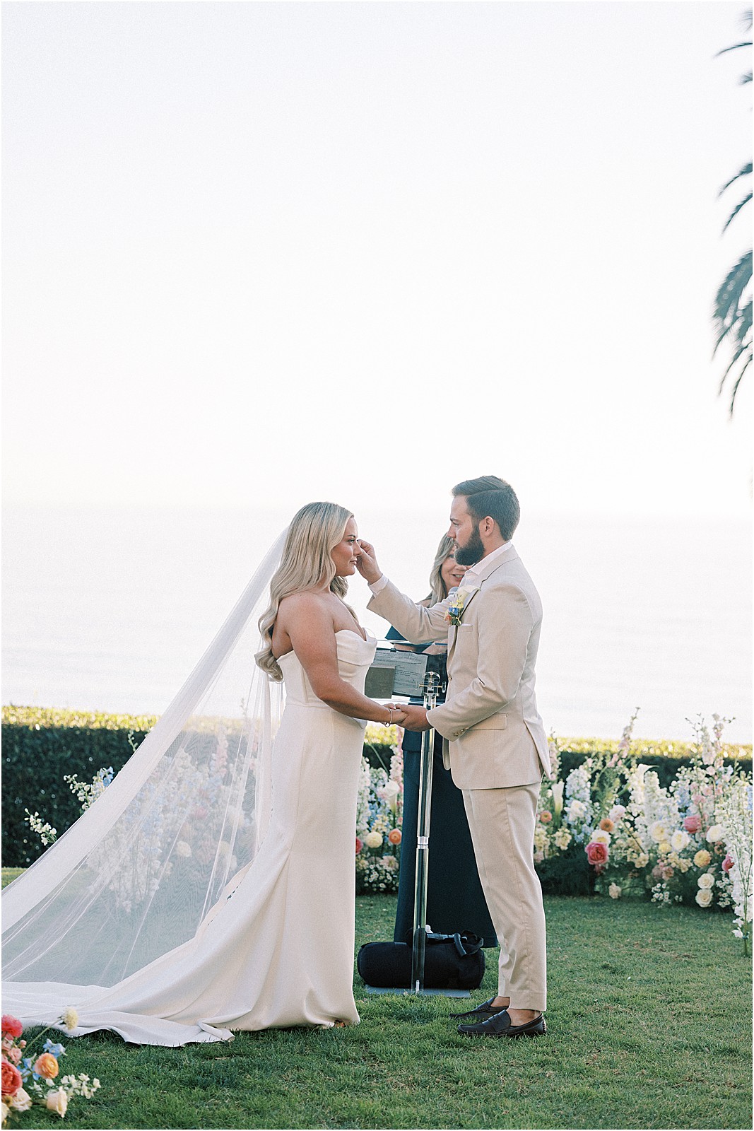groom wiping bride's tear during their wedding vows
