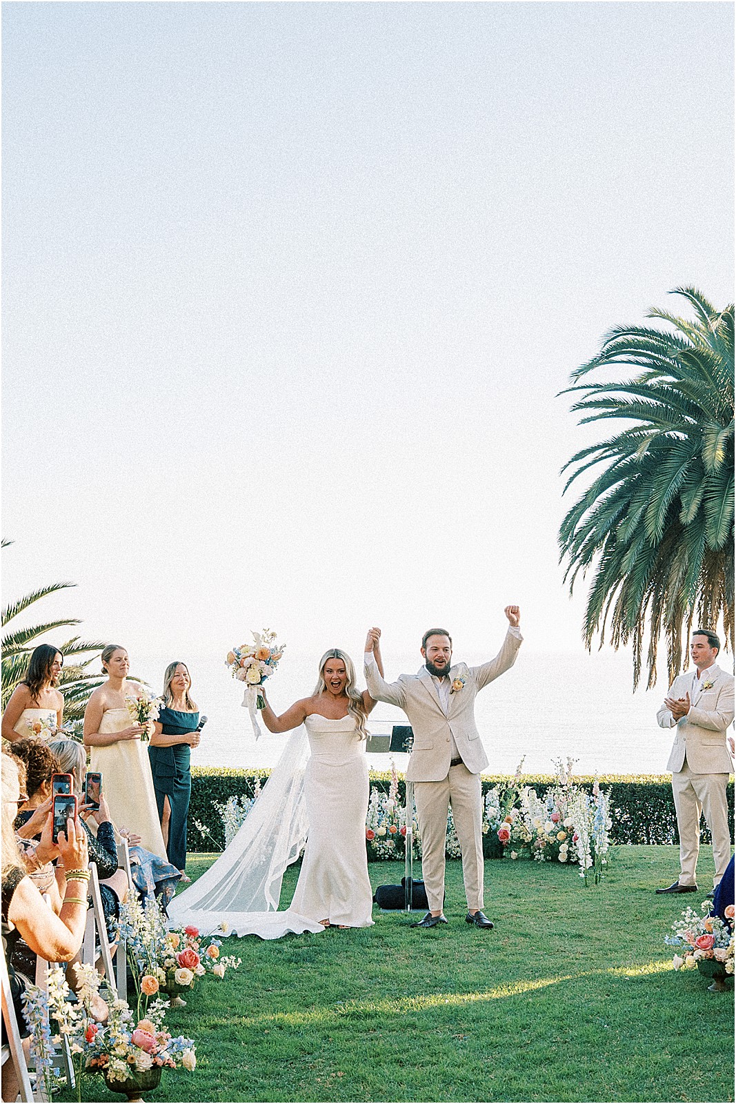 couple celebrating their marriage before they walk back up the aisle at bel air bay club