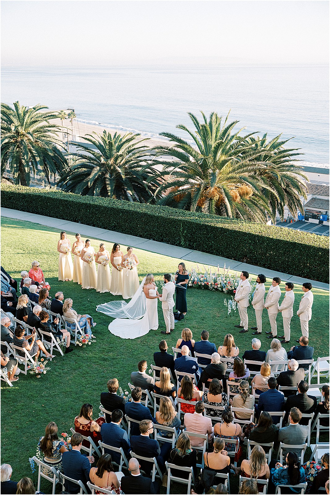 wide ceremony photo with guests and coastal scenery