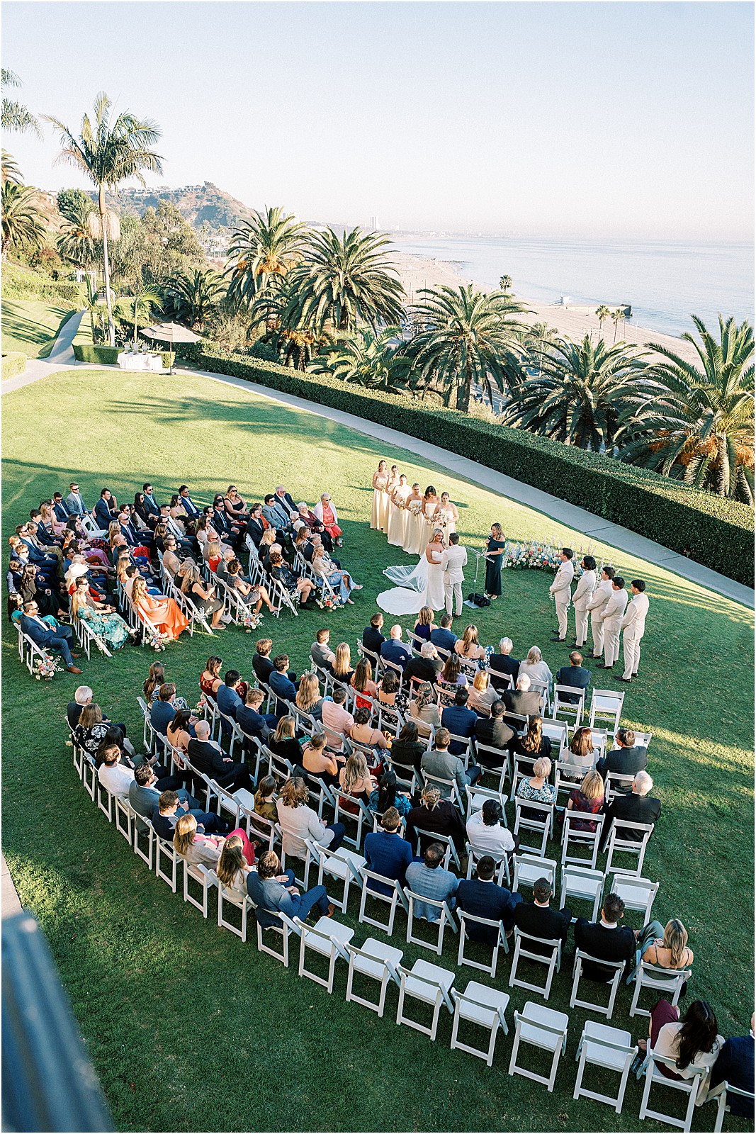 wide ceremony photo with guests and coastal scenery