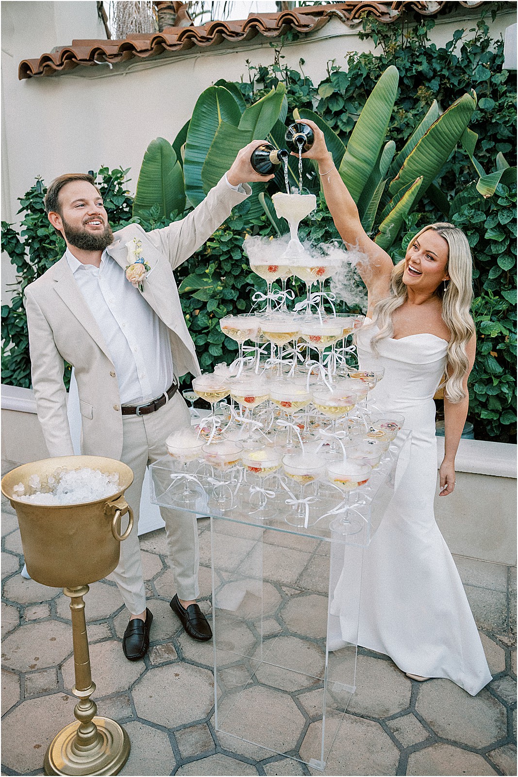champagne tower being poured by the bride and groom
