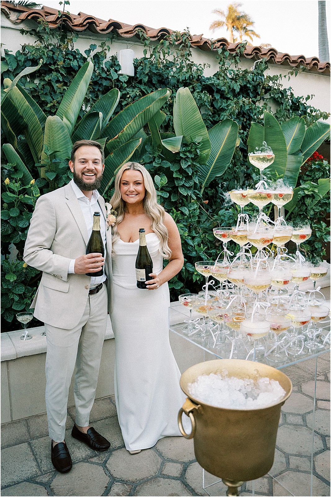 couple standing next to champagne tower to pose for a photo