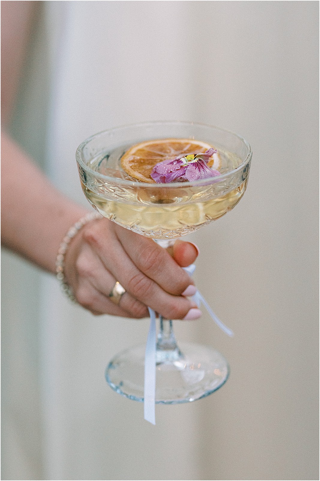 bridesmaid holding a glass of champagne with flowers